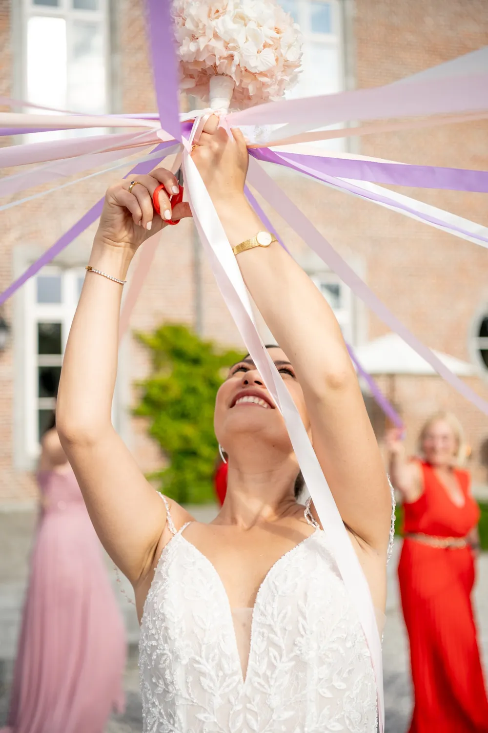 La mariée attrape le bouquet suspendu à des rubans